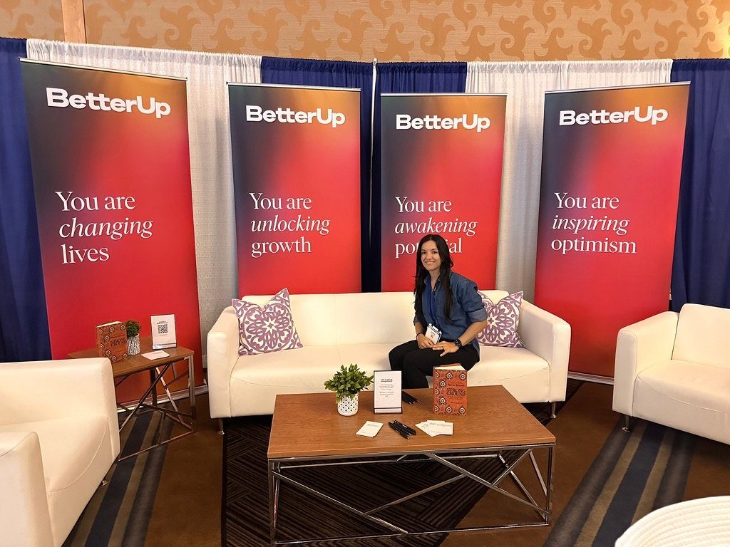 Romi seated in the BetterUp coach lounge at a coaching conference
